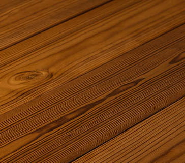 Outdoor view of wood fired hot tub with dark interior, wooden steps, towel rack, and hexagonal sauna cabin nearby