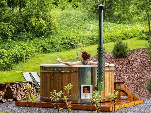 Žena relaxuje v zahradní vířivce Gardenvity na dřevo.